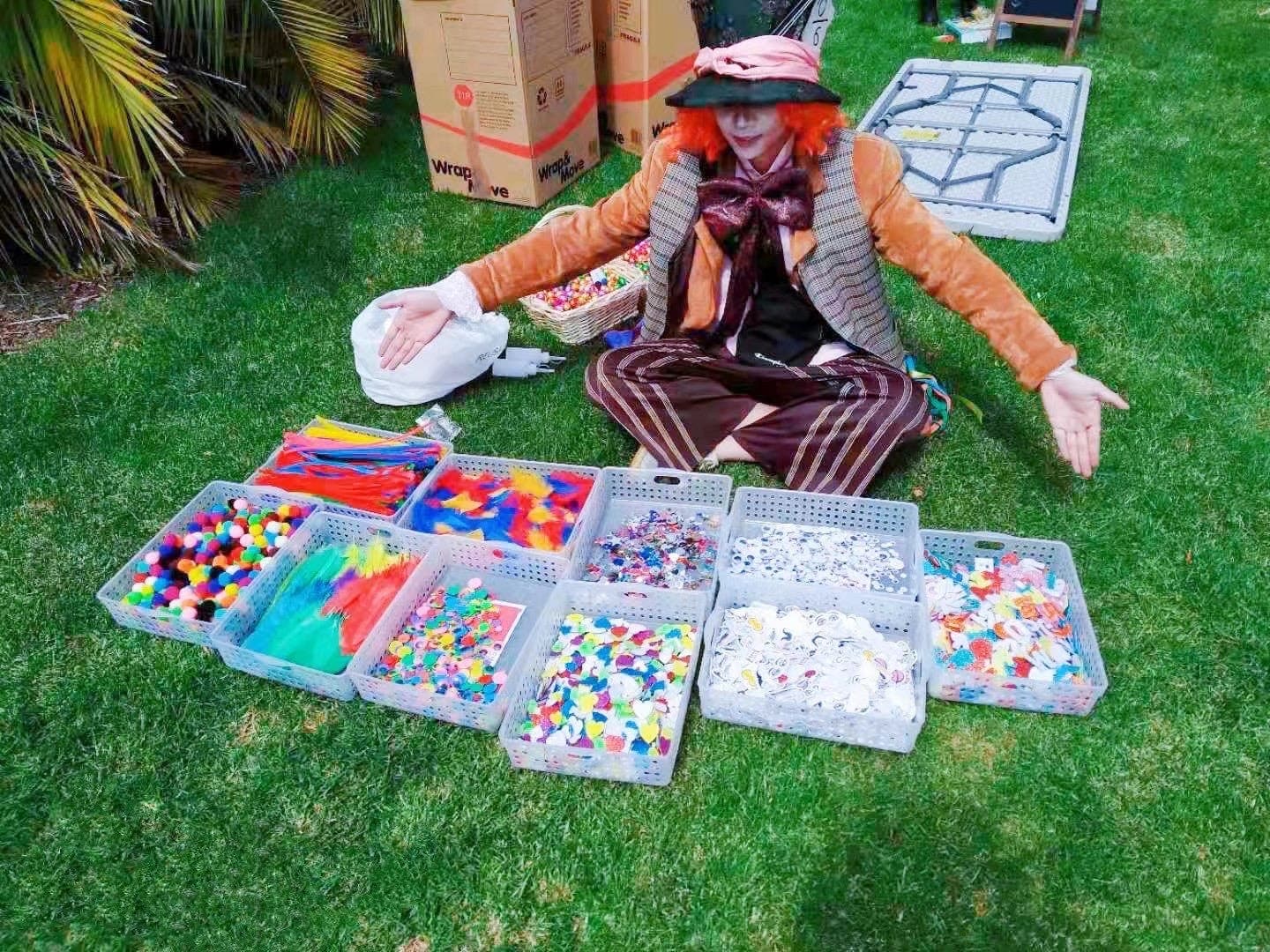 Man sitting on grass selling colorful kits